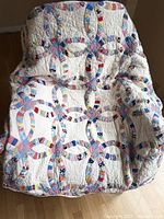 Quilt draped over chair showing patchwork rings and texture