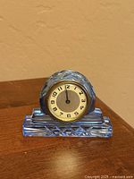 Front view of blue cut crystal desk clock on wooden surface