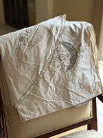 Tablecloth folded on chair showing fabric and embroidery