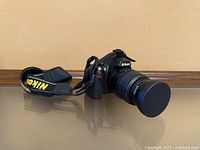 Full view of camera with lens, cap and strap