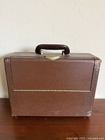Closed briefcase-style radio showing exterior case and handle
