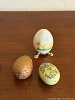 Three decorative eggs shown together on wooden surface