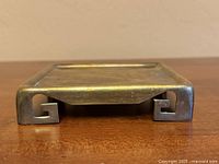 square brass stand side view showing scroll legs