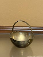 front view showing entire brass basket shape and handle