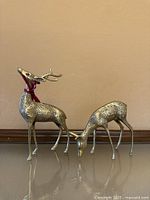 Both brass reindeer figurines side by side