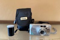 Front view of Canon Sure Shot Z155 camera, Canon case, film canister
