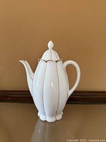 Front view of white porcelain coffee/tea pot with gold trim