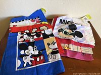Stack of folded character scarves showing multiple Mickey designs