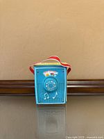 Front view showing blue plastic body, turning dial, front decal and carry strap