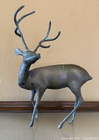 Full view of bronze stag sculpture showing stance and antlers