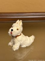 Front side view of white plush dog with collar