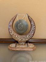 Full view of inlaid wooden stand and brass gong