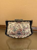 Front view of petit-point floral tapestry purse showing clasp and chain