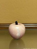 front view of pink marble apple with dark stem