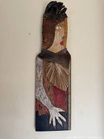 Full view of tall mixed media wooden sculpture hanging on wall