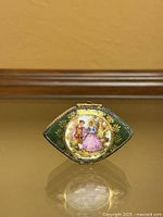 Front view showing green porcelain box, gold decoration, Fragonard couple scene