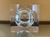 front view of clear lucite cube showing spherical interior