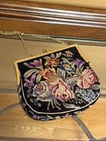 Front view of floral needlepoint purse showing entire design and chain strap