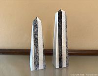 Front view of both marble obelisks showing striped pattern and relative heights