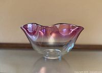 Side view showing amethyst ombre coloration, ruffled rim, footed base