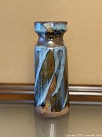 Front view of stoneware vase showing brown base glaze and blue brushstroke pattern