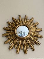 Front view of gilded Palladio sunburst mirror on wall