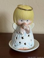 front view of ceramic praying angel tealight cover showing star cutouts and halo rim