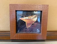 Full view of framed photograph, showing boat image and frame texture
