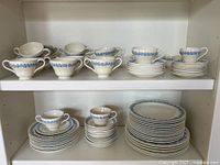 Overall view of entire set on shelves showing cups, saucers and plates
