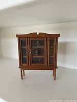 Front view of wooden miniature cabinet with glass doors