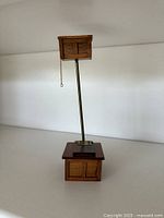 Full view of wooden miniature high-tank toilet showing cistern, metal rod and base