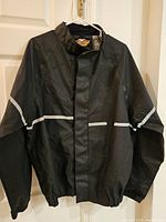 Full front view of black Harley-Davidson lightweight jacket on hanger