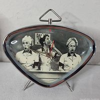 Front view of triangular alarm clock showing I Love Lucy image and dial