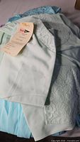 Pile of pastel Shadowline nightgowns showing lace detail and hangtag