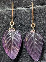 Front view of both earrings showing carved amethyst leaves and gold hooks