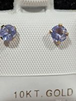 close-up of round tanzanite stud in 10K gold setting