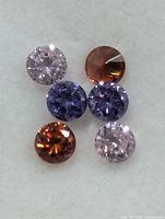 Six round faceted stones various colours on white background