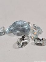 Group of faceted aquamarine stones showing shapes and color