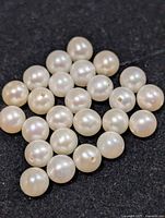 Group of loose drilled cultured pearls on dark background