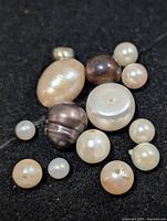 group of 14 mixed pearls on black background