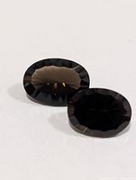 Front view of two oval smokey quartz gems