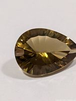 Top view of pear-shaped smoky topaz showing facets and color
