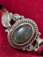 Front view of silver ring showing oval labradorite and rope bezel