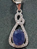 Front view of silver pendant showing sapphire and CZ accents