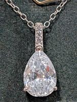 Close view of pear-shaped CZ pendant and pavé bail on chain