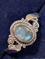 Top view showing oval labradorite stone in rope bezel with side scroll accents