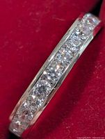 Side view of silver band ring showing channel-set cubic zirconia