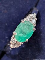 Top view showing oval emerald and clear accent stones