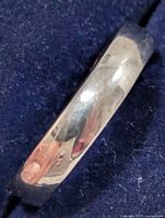 Top view of silver band ring on dark background