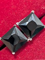 front view showing twin square black onyx stones in silver prong settings